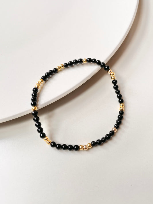 Delicate Black Onyx Bracelet, Adorned with Gold Accents, Offering Protection